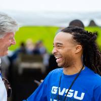 A guest laughing with Randy Banstra at the Jamie Hosford Football Center dedication.